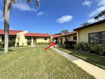 Charming condo featuring a red tile roof, well-maintained lawn, and welcoming walkway at 1423 56Th W St # 1423, Bradenton, FL 34209