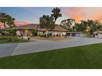 Lovely single-story home featuring a tile roof, mature landscaping, and an expansive driveway leading to a three-car garage at 265 Beaver Ct, Venice, FL 34292