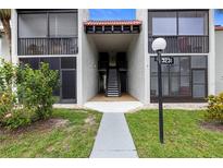 Inviting condo exterior with well-maintained lawn and direct access to upper and lower units, with beautiful plants and an address marker at 3231 Beneva Rd # 101, Sarasota, FL 34232
