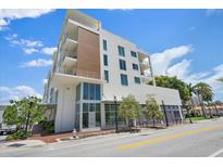 Modern, white exterior with balconies, large windows, and street view, plus a mix of wood and concrete at 332 Cocoanut Ave # 406, Sarasota, FL 34236