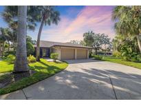 Charming single-story home featuring a two-car garage, lush landscaping, and a long driveway at 6650 Schooner Bay Cir # 6650, Sarasota, FL 34231