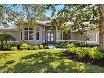 Charming home featuring a beautifully landscaped front yard and a welcoming entryway at 8579 Woodbriar Dr, Sarasota, FL 34238