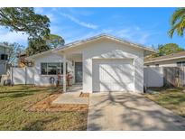 Charming single Gathering home with a well-maintained lawn and a driveway leading to a one car garage at 1719 New Hampshire Ne Ave, St Petersburg, FL 33703