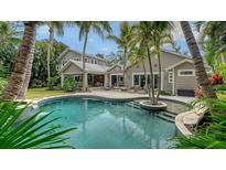 Resort style pool and patio surrounded by palm trees at this gorgeous home at 1919 Irving St, Sarasota, FL 34236