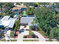 Charming single-story home with lush landscaping and a paved driveway, surrounded by mature trees at 3530 Flores Ave, Sarasota, FL 34239