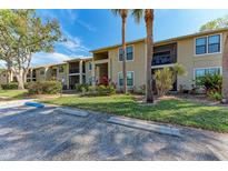 Inviting two-story condo building featuring well-maintained landscaping, palm trees and ample parking at 4061 Crockers Lake Blvd # 2611, Sarasota, FL 34238