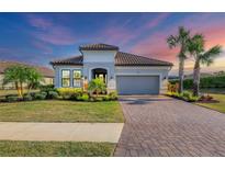 Charming single-story home featuring a tile roof, paver driveway, well manicured landscaping, and a two-car garage at 4543 Terrazza Ct, Lakewood Ranch, FL 34211