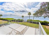 Relaxing balcony with white railing overlooking water and clear blue sky with two lounge chairs facing scenic waterfront views at 55 Tidy Island Blvd, Bradenton, FL 34210