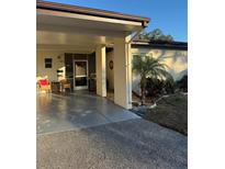 Charming home featuring a covered parking area with seating and a well-maintained, landscaped yard with a small palm tree at 6205 Green View Dr # 129, Sarasota, FL 34231