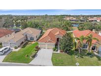 Beautiful exterior of the home with a red tile roof, lush landscaping, and an attached two-car garage at 6540 Tailfeather Way, Bradenton, FL 34203