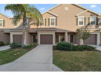 Charming townhome featuring a well-manicured lawn, brown shutters, and a private one car garage at 1038 Grantham Dr, Sarasota, FL 34234