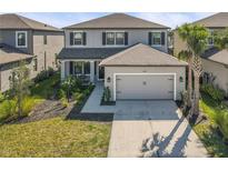 Charming two-story home with a two-car garage, manicured lawn and tropical landscaping at 8609 Evening Dr, Sarasota, FL 34241