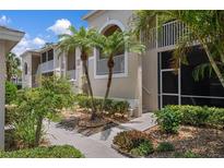 Charming condo building exterior with well-manicured landscaping and screened balconies in a lush setting at 9540 High Gate Dr # 1426, Sarasota, FL 34238