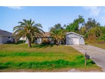 Charming single-story home features a well-maintained front yard with mature palm trees and a private driveway at 1124 Ample Ave, Port Charlotte, FL 33948