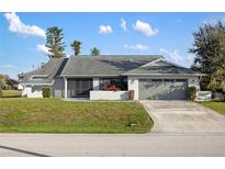 Charming single-story home featuring well-maintained landscaping and a two-car garage at 124 Mark Twain Ln, Rotonda West, FL 33947