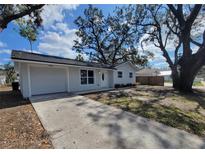 Charming one-story home with a well-maintained lawn, inviting entrance and large shade trees at 3325 Woodmont Dr, Sarasota, FL 34232