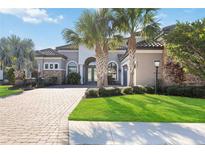 Beautiful home with a well-manicured lawn, palm trees, and a brick driveway at 4744 Benito Ct, Bradenton, FL 34211