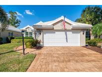 Home exterior with a two-car garage, brick driveway and mature landscaping at 538 Fallbrook Dr, Venice, FL 34292