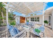 Inviting outdoor patio area with white pergola, comfortable seating, and modern fire pit for relaxing evenings at 615 Avenida Del Norte, Sarasota, FL 34242