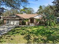 Charming single-story home featuring a manicured front lawn, brick accents, and mature landscaping at 1612 Pine Harrier Cir, Sarasota, FL 34231