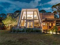 Stunning home featuring A-frame windows, a charming front porch, and lush landscaping at 1627 Bayshore Dr, Englewood, FL 34223