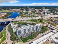 Stunning aerial view of a condo building surrounded by lush greenery, with a waterfront and highway nearby at 201 W Laurel St # 209, Tampa, FL 33602