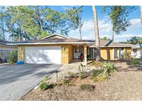 Charming single-story home featuring a spacious two-car garage and a welcoming entrance, nestled amidst lush trees at 2118 Wells Av, Sarasota, FL 34232