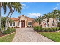 Charming single-story home showcasing lush landscaping, a paver driveway, and a red tile roof at 4245 Corso Venetia Blvd, Venice, FL 34293