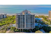 Luxury high-rise condo building with beautiful ocean views, lush landscaping, and a swimming pool at 1211 Gulf Of Mexico Dr # 701, Longboat Key, FL 34228