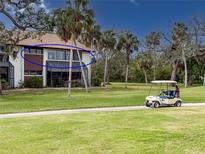 Condo on golf course with palm trees and golf cart on path at 6071 Fairway Ln # 1424, Bradenton, FL 34210