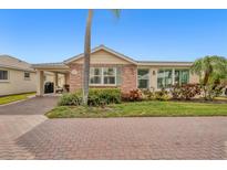 Charming single-story home featuring brick accents, lush landscaping, and a brick-paved driveway at 6140 Midnight Pass Rd # B6, Sarasota, FL 34242