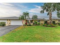 Charming villa featuring an attached garage, meticulous landscaping, and a spacious well-manicured lawn at 7061 W Country Club N Dr, Sarasota, FL 34243