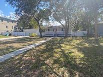 Charming single-story home featuring a welcoming front porch, neutral siding, and a well-maintained front yard at 916 Michigan Ave, Palm Harbor, FL 34683