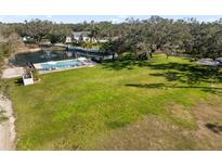 Expansive backyard featuring lush lawn, pool, and pond with fountain at 1228 Wagon Wheel Dr, Sarasota, FL 34240
