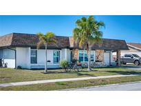 Charming single-story home with stone accents, landscaped lawn, attached garage and cozy curb appeal at 13575 Martha Ave, Port Charlotte, FL 33981