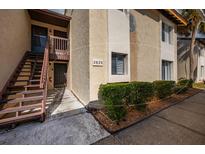 Condo exterior showcasing well-maintained landscaping, stairs, and building number for easy identification at 2625 Pine Lake Ter # B, Sarasota, FL 34237