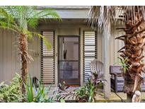 Inviting front door with tropical landscaping, seating, and screened entry at 308 Pine Run Dr, Osprey, FL 34229