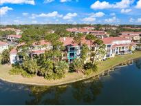 Beautiful exterior view of a condo complex surrounded by lush trees and a serene lake at 5552 Bentgrass Dr # 7-116, Sarasota, FL 34235