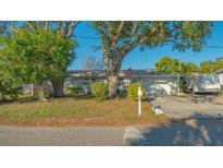 Charming single-story home with mature trees, manicured lawn, and a classic American mailbox at 7272 Cass Cir, Sarasota, FL 34231