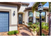 Elegant home featuring a brick walkway, garden details and inviting front entrance at 7311 Summerland Cv, Bradenton, FL 34202