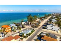 Charming beach house with a view of the ocean, palm trees, and white sand at 912 N Shore Dr, Anna Maria, FL 34216