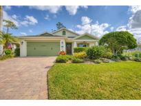 Charming single-story home with a well-manicured lawn, lush landscaping, and a brick driveway at 201 San Lorenzo Ct, Bradenton, FL 34208