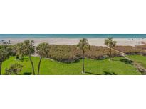 Expansive view of the beach with palm trees and lush greenery from an elevated vantage point at 2675 Gulf Of Mexico Dr # 301, Longboat Key, FL 34228