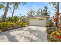 Charming home with well-manicured landscaping, a spacious driveway, and a two-car garage at 28 Tall Trees Ct, Sarasota, FL 34232