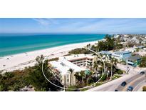 Beautiful aerial view of a condo building with a sandy beach and ocean in the background at 4200 Gulf Dr # 101, Holmes Beach, FL 34217