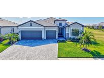 Beautiful home featuring a three-car garage and a well-manicured lawn with lush landscaping at 4968 Seafoam Trl, Bradenton, FL 34211