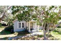 Charming single-story home featuring mature trees and a welcoming front porch with classic column supports at 617 35Th W St, Bradenton, FL 34205