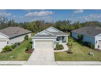 Charming single-story home with a well-manicured lawn and a two-car garage at 13540 Old Creek Ct, Parrish, FL 34219