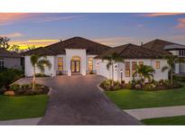 Stunning single-story home with a tile roof, brick driveway, and professionally landscaped grounds at 14803 Derna Ter, Bradenton, FL 34211