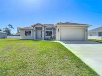 Well-manicured lawn and tidy landscaping complement this single Gathering home's neutral exterior at 2186 Yalta Ter, North Port, FL 34286